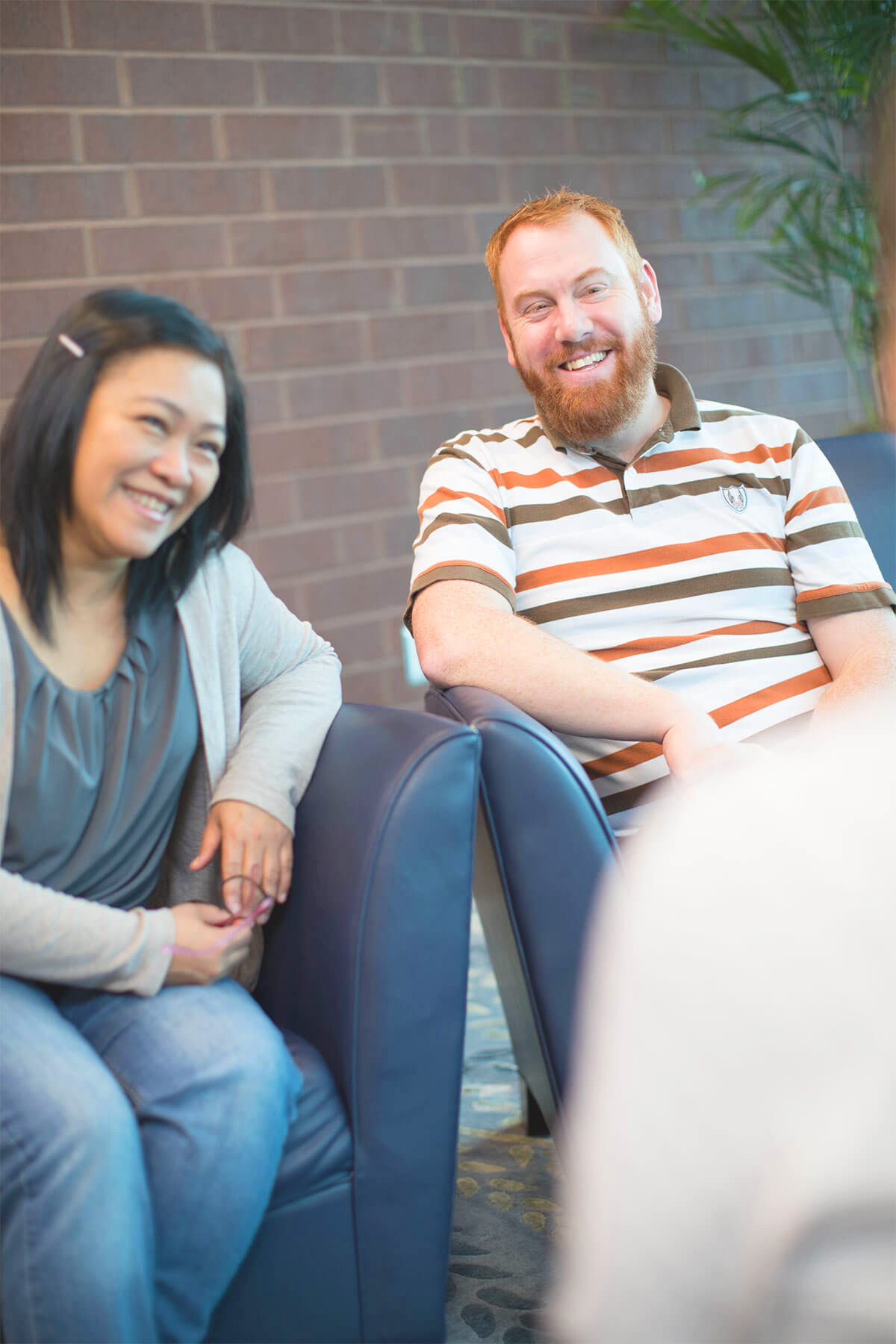 While sitting across from an insurance broker, a couple discusses insurance plans.