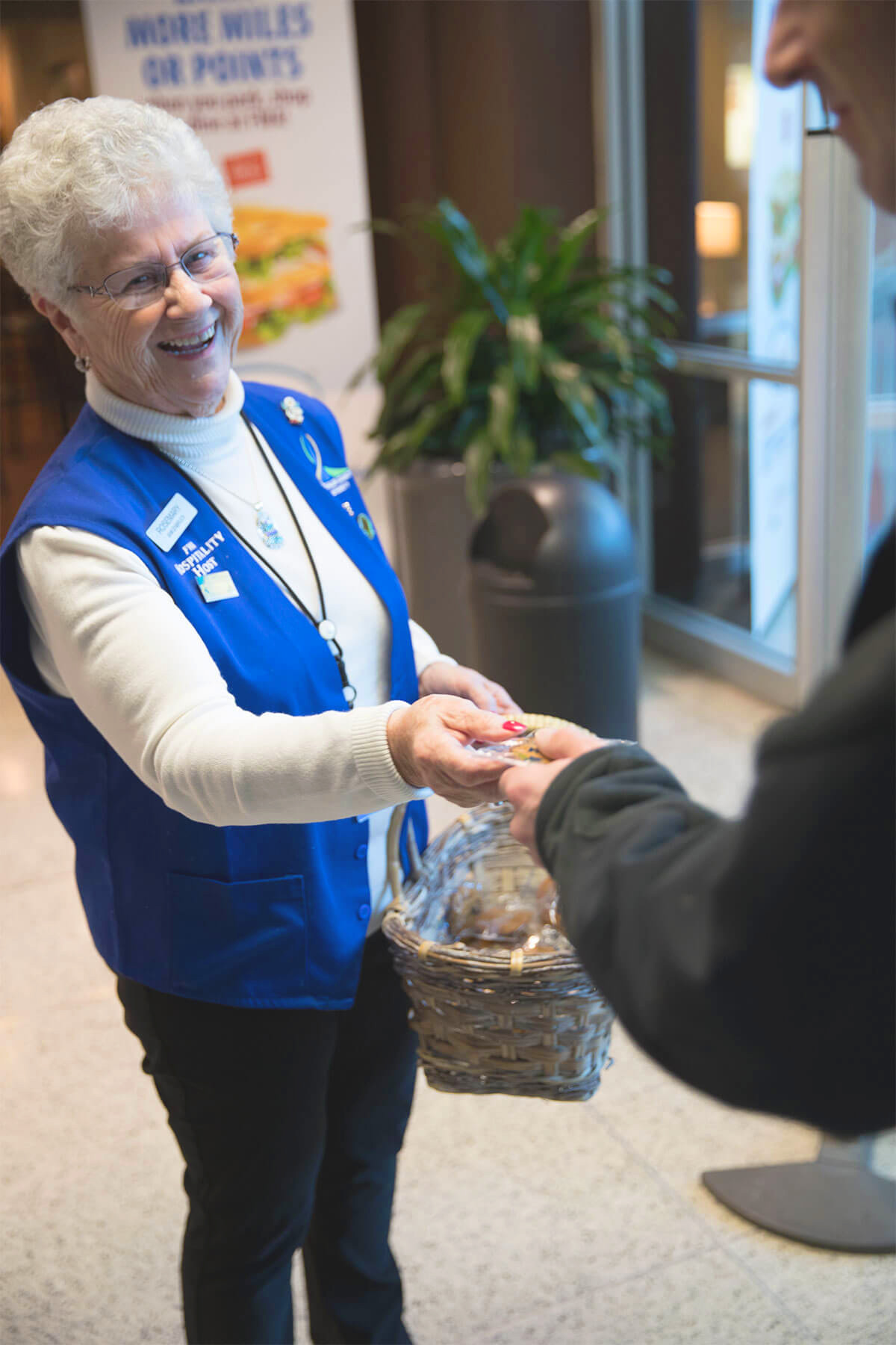 A woman is handing a cookie to the passengers who just landed at the Fort Wayne airport