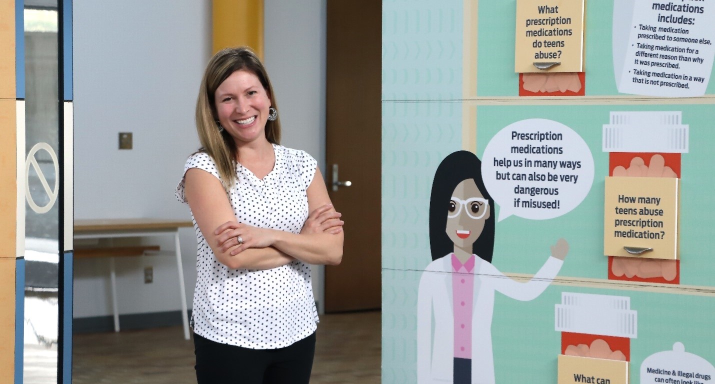 Nicole Fairchild of McMillen Health standing beside Informational Center