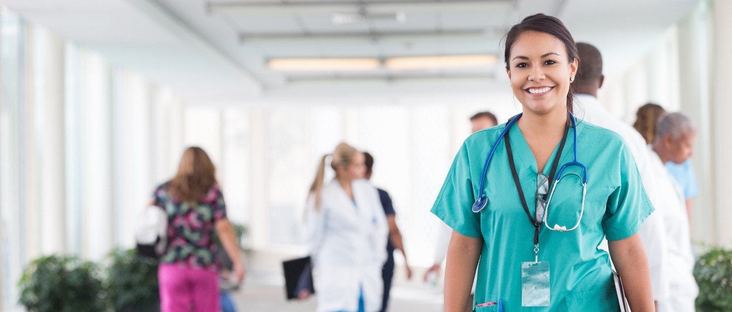 Physician smiling with staff members in the background